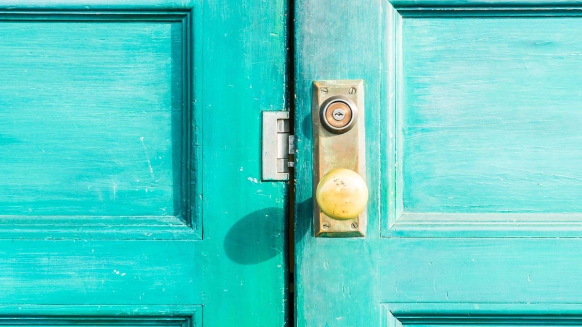 Detailed image of a green door adorned with a vibrant yellow handle, showcasing the unique color combination.