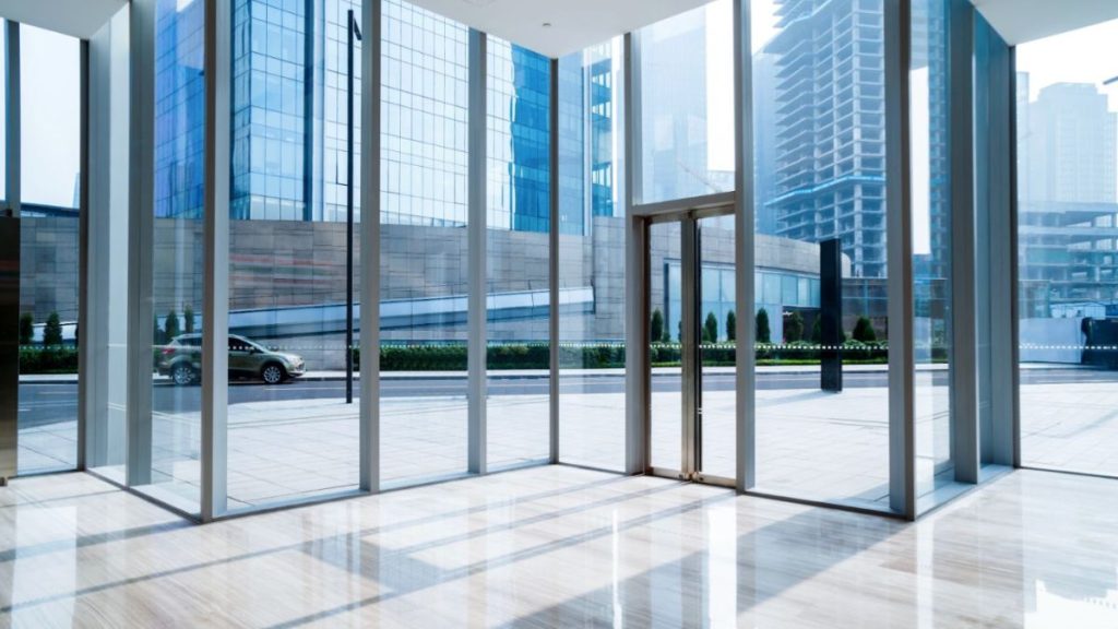 A large glass door in a contemporary building, flanked by tall windows that enhance the modern architectural design.