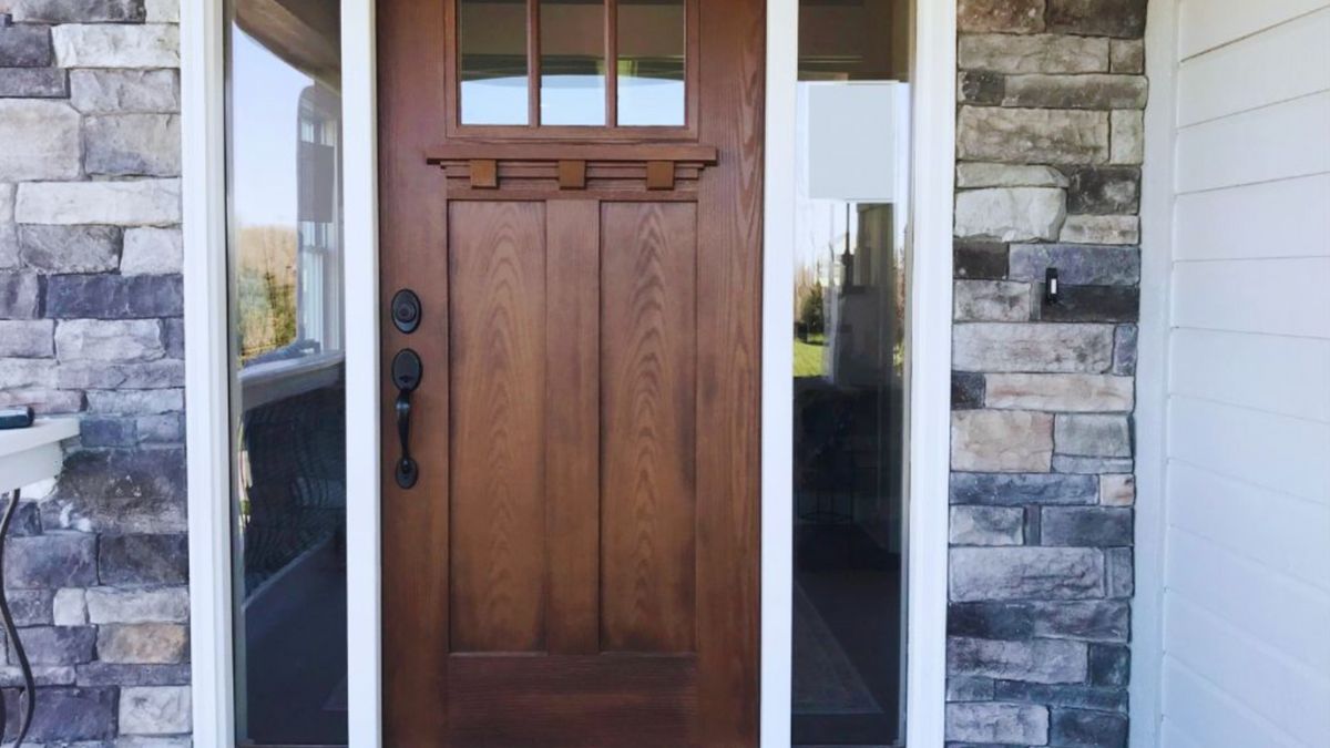 A functional and attractive fiberglass entry door featuring a wooden frame and glass panel.