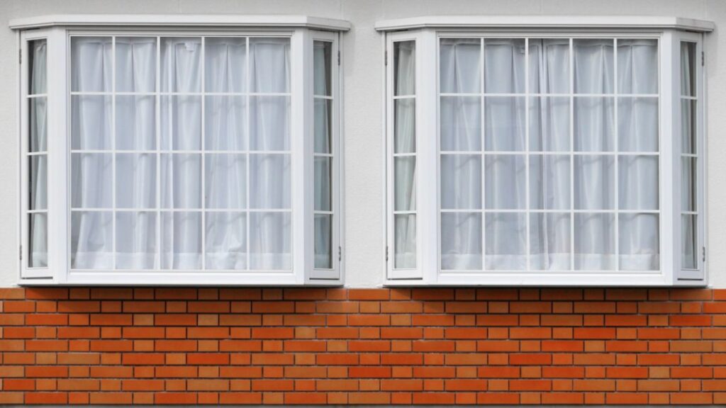 A pair of open casement windows in a rustic brick wall, illustrating their versatility in both modern and traditional architectural styles.