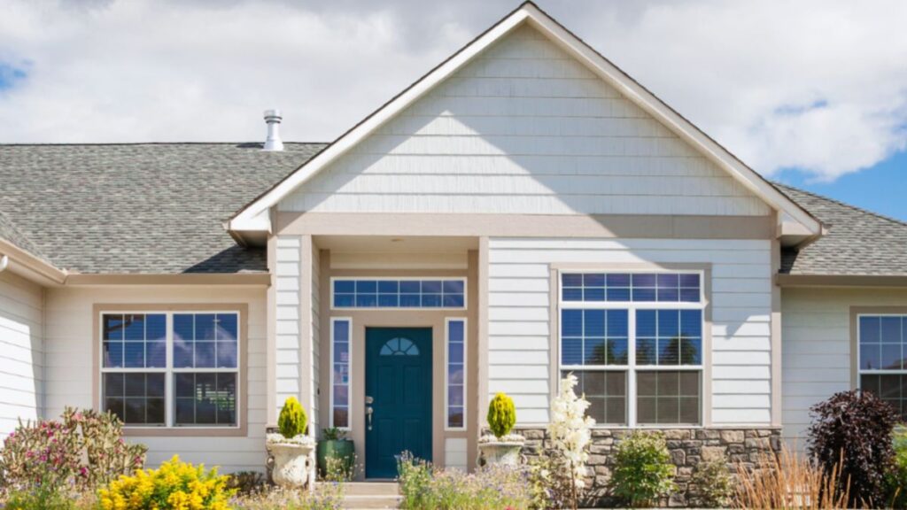 A charming home featuring a green front door, complemented by transom windows and sidelights from HHI Windows and Doors.