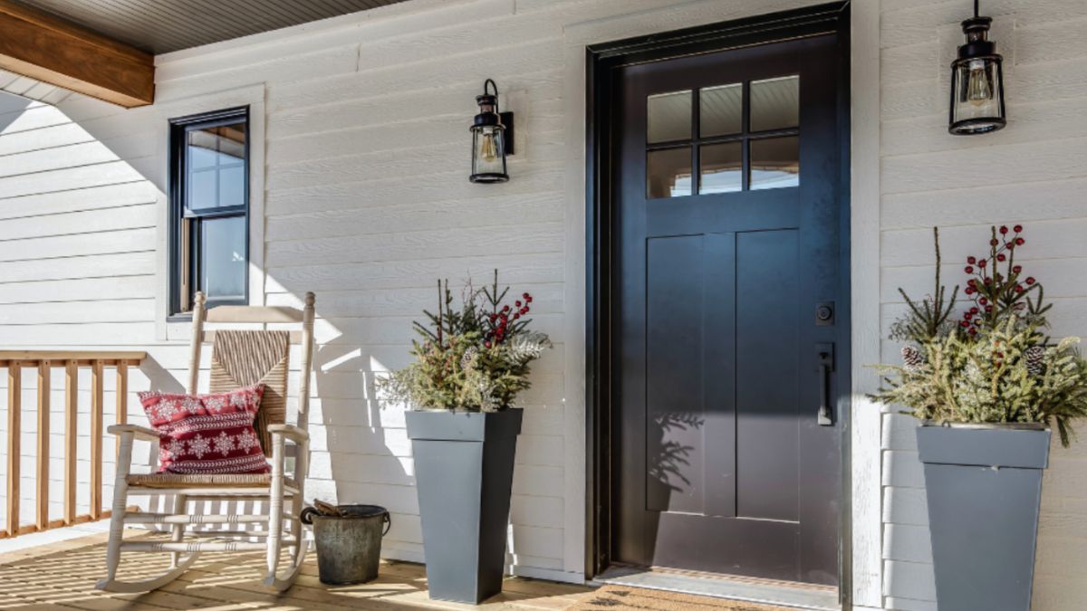 A cozy porch featuring a rocking chair and a sleek door, inviting relaxation and comfort.