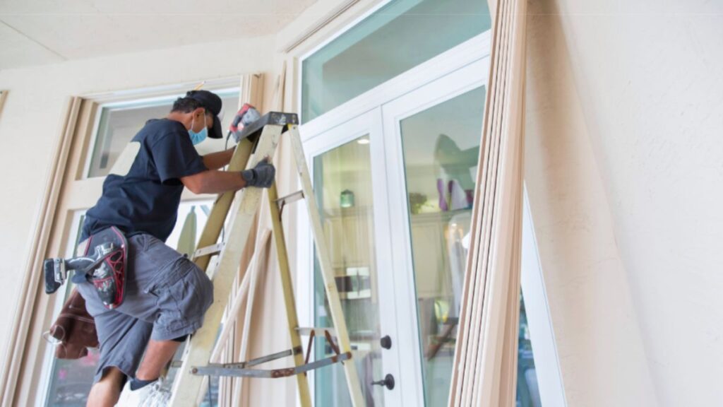 An installer on a ladder showcasing the skilled door installation by HHI Windows and Doors.