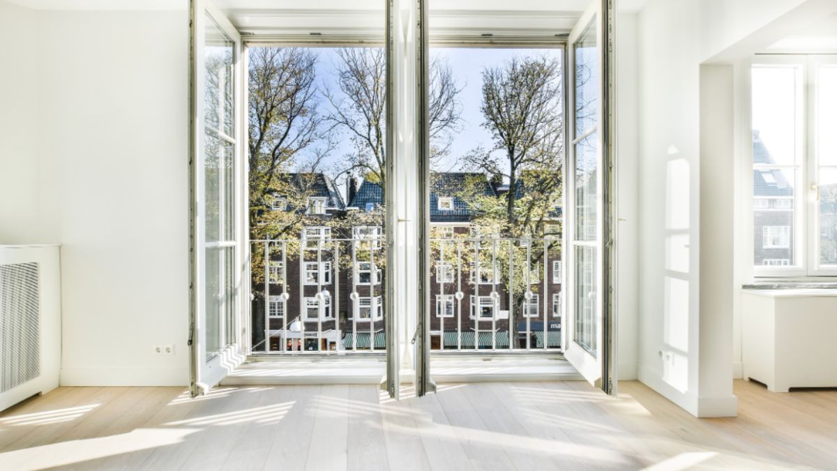 A large window framed by white walls offering a panoramic view of the bustling cityscape outside.