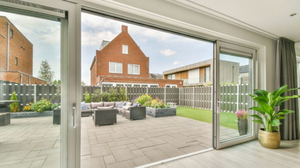 A serene patio scene showcasing a sliding glass patio door and a seating area, perfect for outdoor gatherings.