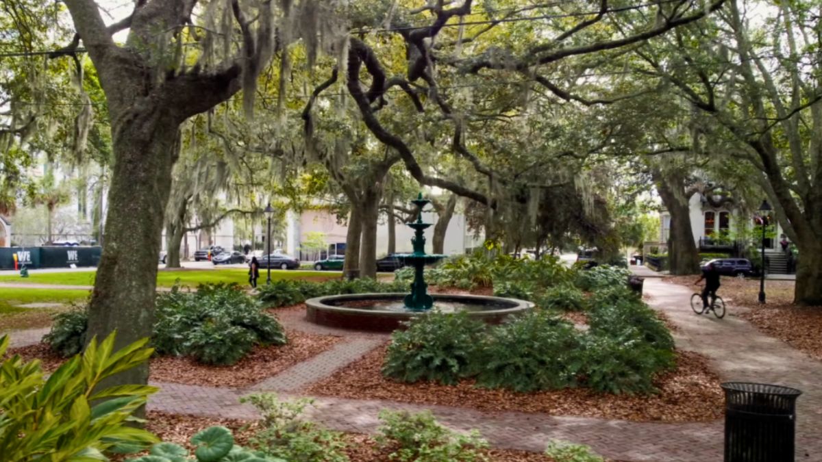 A picturesque landscape of Lafayette Square, Savannah, GA, highlighting its beautiful gardens and rich natural beauty, reflecting the city's allure.