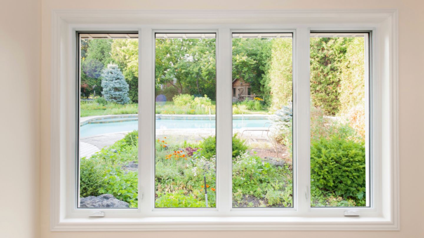 Energy-efficient replacement windows with a clear view of a garden and pool.