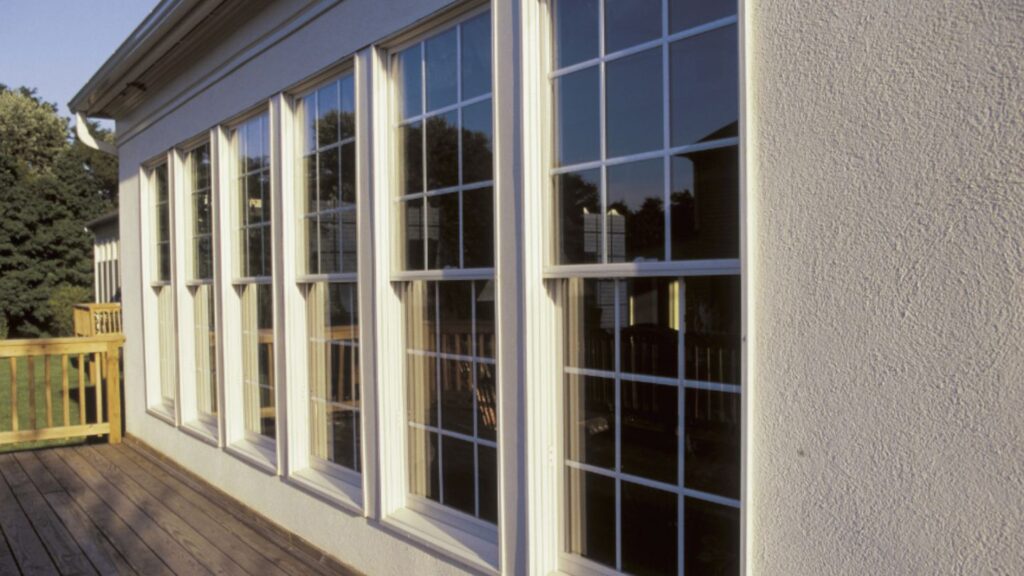 A wooden deck in a Coosawhatchie home featuring large windows that open to a scenic, peaceful view.