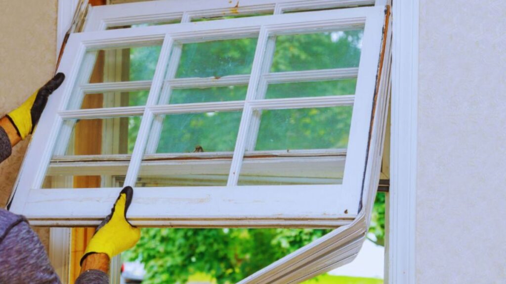 A man installs a window, showcasing professional replacement services.